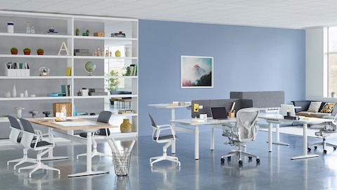 Een samenwerkingsset met een cluster van sit-to-stand-desks en een rechthoekige tafel van Atlas Office Landscape.