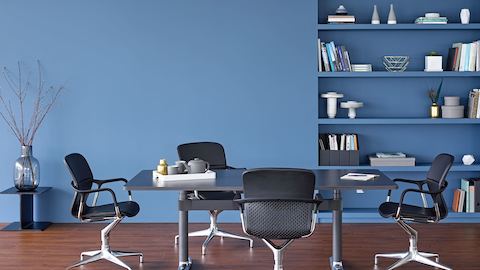 Vier Keyn-Stühle umrahmen einen rechteckigen Tisch Atlas Office Landscape mit einer schwarzen Platte.