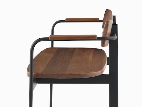 A Betwixt Bench with walnut seat, backrest, and arms with a black frame.