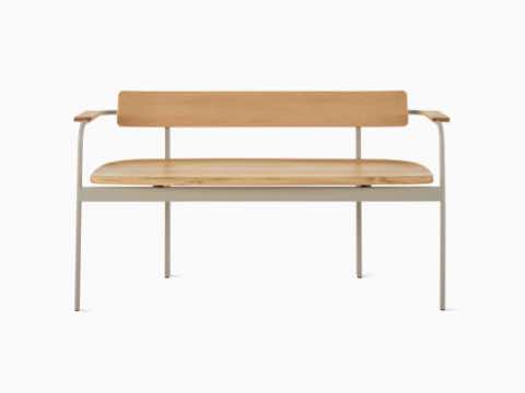 A Betwixt Bench with oak seat, backrest, and arms with a grey frame.