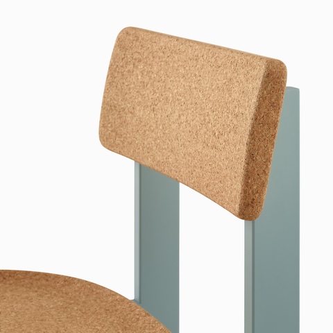 A close up of a Betwixt Chair with cork seat and backrest and a glacier frame. 