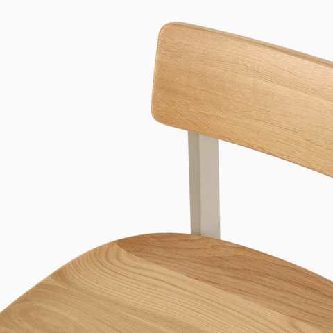 A close up of a Betwixt Stool with oak seat and back with a grey frame.