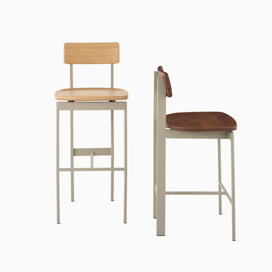 Dos taburetes Betwixt con asiento y respaldo de madera y estructura en gris.