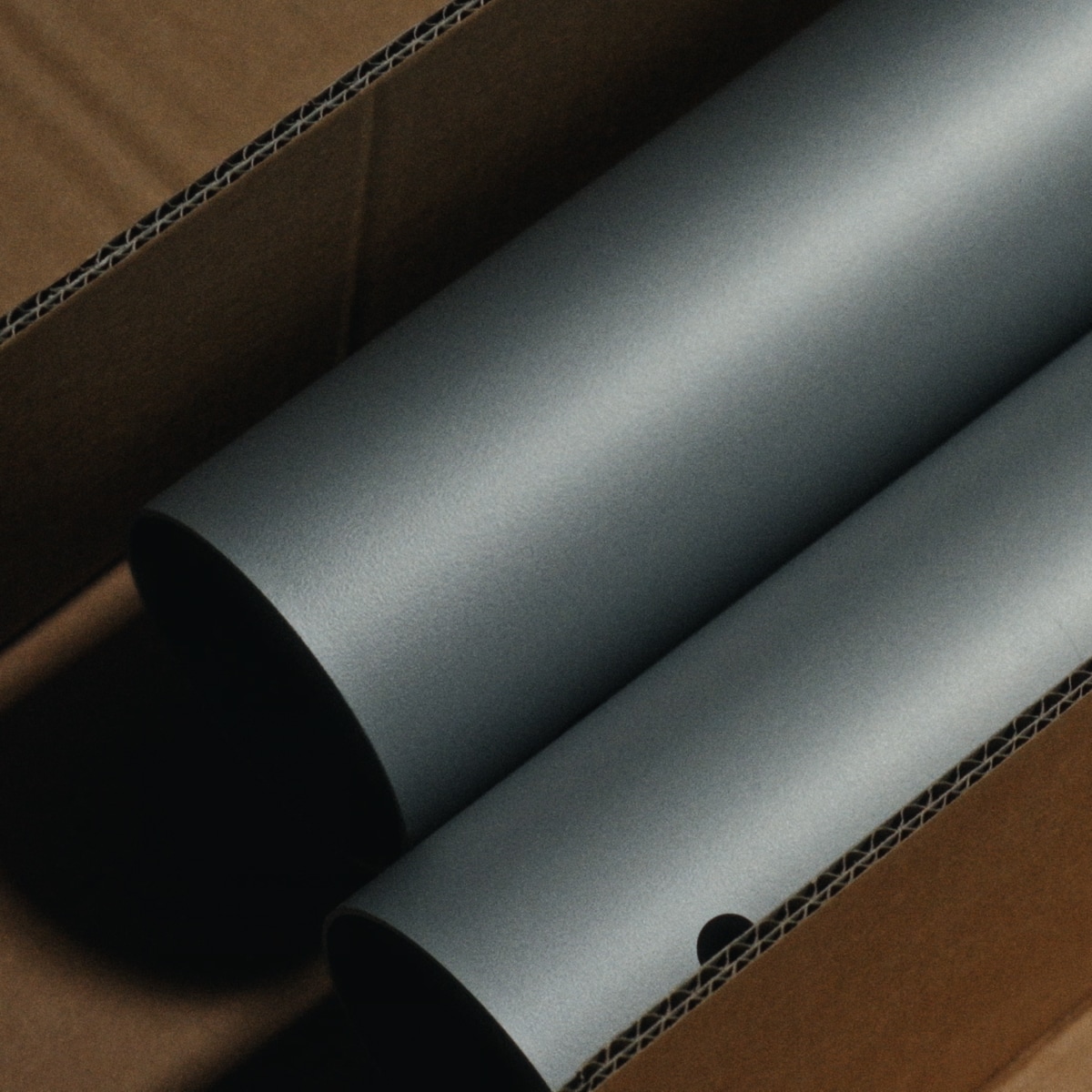 A close-up view of Boa Table aluminum legs flat in box.