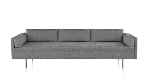 Bolster Sofa mit grau meliertem Textilbezug und matt verchromten Beinen, von vorne betrachtet.