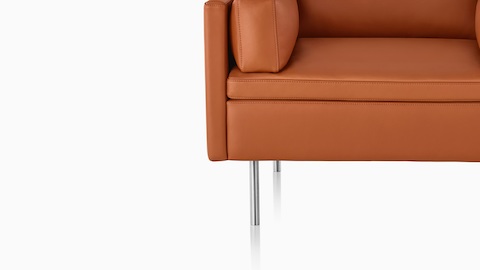 Close up of Bolster Sofa with tan leather upholstery and bright chrome base. Close up of Bolster Sofa with tan leather upholstery and bright chrome base.