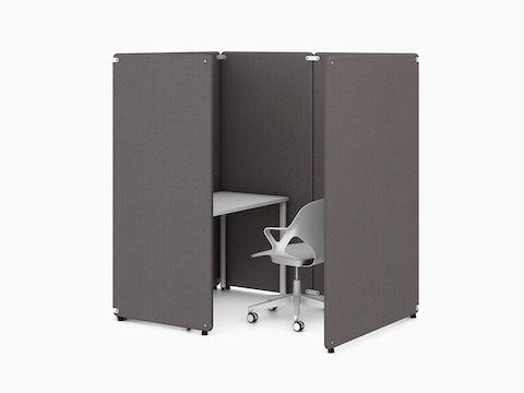 Quattro schermi divisori indipendenti grigio scuro in una configurazione a cabina intorno a un tavolo bianco rettangolare OE1 con una sedia bianca Zeph, visto da un angolo.