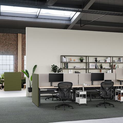 Een kantooropstelling met Ratio-werkstations met groene en grijze Bound-schermen en zwarte Aeron-stoelen.