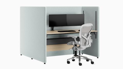Angled view of back-to-back blue two person configuration of Bound Sit-Stand Desking, shown with Aeron chair and dual monitor.