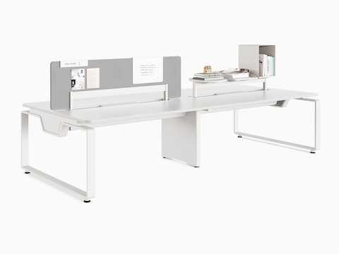 Byne System with Arras legs in 4-seat bench setting, with a screen on one desk and accessories on the other.