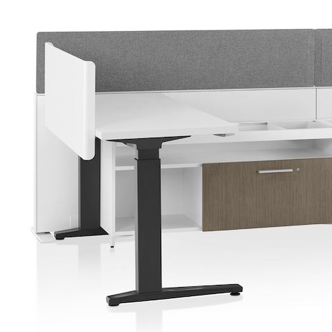 A close-up image of a Canvas Channel workstation with lower storage, grey fabric screens, and Motia height-adjustable table.