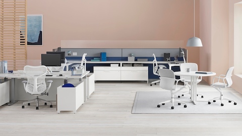 An office with Canvas Channel and Canvas Wall workstations with glass screens, white desks, lower storage, and white Mirra 2 office chairs.