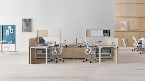 Una estación de trabajo Canvas Dock con 4 escritorios, almacenamiento superior y sillas para oficina Mirra 2 grises.