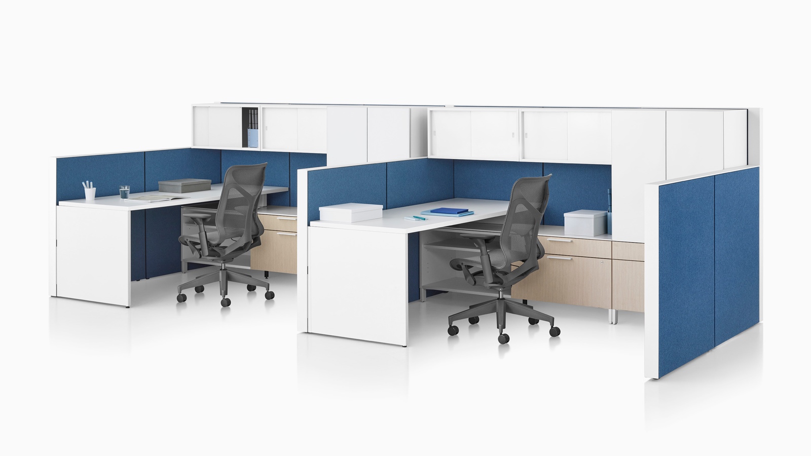 A Canvas Wall workstation with blue panels and white overhead storage.