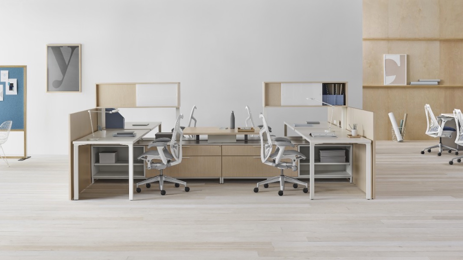 A Canvas Dock workstation with upper storage, gallery panels, and gray Mirra 2 office chairs. Select to go to the Individual Workstations page within the Canvas Lookbook.