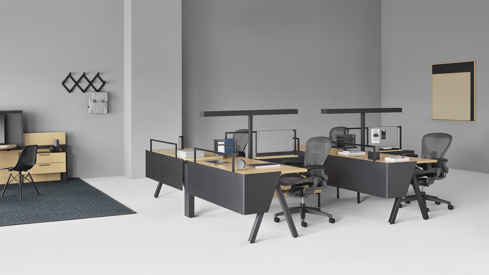 A Canvas Vista workstation with black Aeron office chairs in the foreground and a Canvas Vista collaborative space with display unit in the background. Select to go to the Small Workstations page within the Canvas Lookbook.