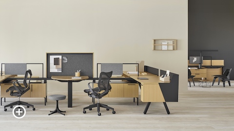 A Canvas Vista workstation with a collaborative area and black Cosm office chairs in the foreground and a Canvas Vista collaborative area in the background. Select to go to the Collaborative Workspaces page within the Canvas Lookbook.