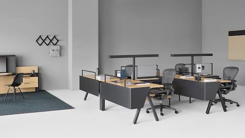 Estações de trabalho Canvas Vista com cadeiras de escritório Aeron pretas e espaço colaborativo Canvas Vista ao fundo.