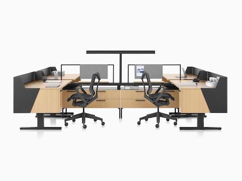 Estaciones de trabajo Canvas Vista en madera clara y negro con pantallas de recato, una luz en forma de T y sillas para oficinas Cosm negras.