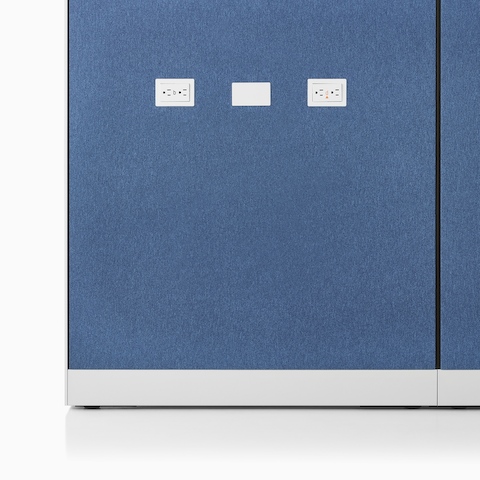 Imagem em close-up de um painel Canvas Wall em tecido azul com tomadas de força e portas de dados.