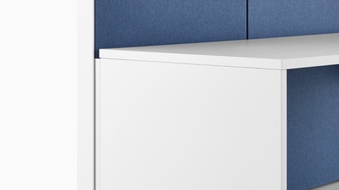 A close-up image of a Canvas Wall workstation with blue panels and white overhead storage.