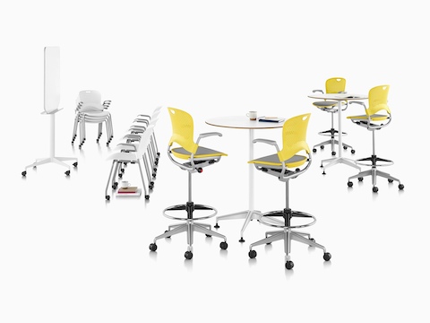 Four yellow Caper Multipurpose Stools with suspension seats around two standing-height round tables. 
