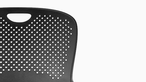 Close view of the perforated back on a black Caper Multipurpose Stool. 