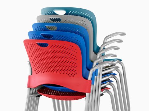 Rear view of red, dark blue, light blue, green, and yellow Caper Stacking Chairs stacked five-high.