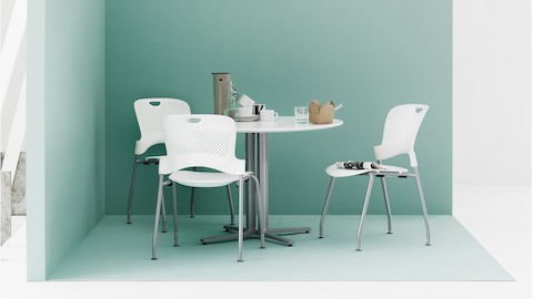 Breekruimte met drie witte Caper-stapelstoelen rond een witte Everywhere-tafel.