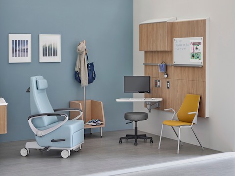 A patient recliner, side chair, and stool in an exam room. 