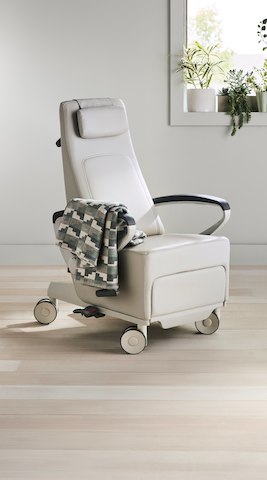 Three-quarter, right view of a light gray Ava recliner with a blanket draped over the arm.