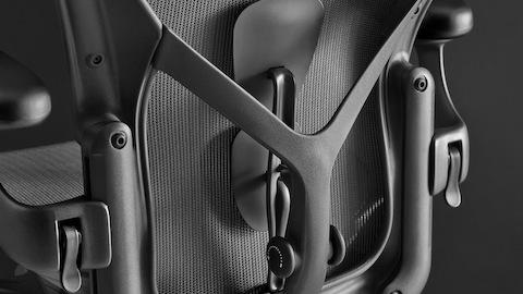 Vue arrière d'une chaise de bureau ergonomique Aeron noire montrant le dossier PostureFit SL et les bras réglables en hauteur.