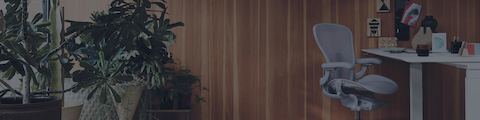 Una oficina en el hogar llena de plantas, con la silla Aeron arrimada por debajo del escritorio Renew Sit-To-Stand, en el ángulo derecho. Una oficina en el hogar llena de plantas, con la silla Aeron arrimada por debajo del escritorio Renew Sit-To-Stand, en el ángulo derecho.
