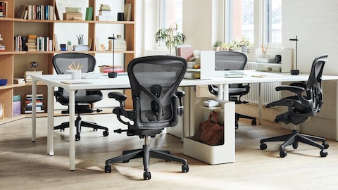 Ein offenes Büro mit vier Schreibtischen in Zweierpaaren, je mit einem Aeron Stuhl dazu.