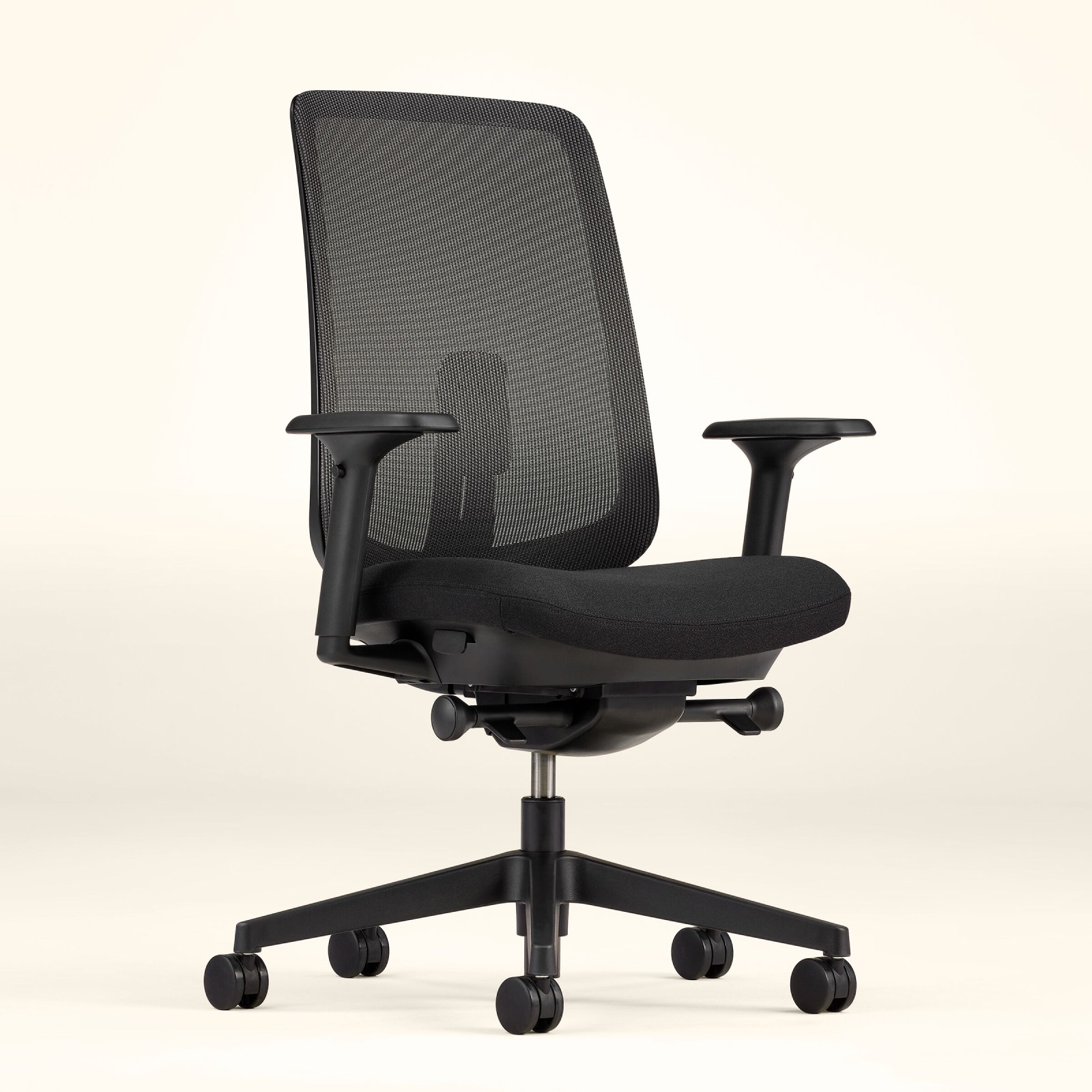 Ein Verus Stuhl mit Membran-Rückenlehne, Sitzfläche und Rahmen in Schwarz vor einem blassgelben Hintergrund, im schrägen Winkel betrachtet.