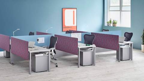 Pari Screens in light blue and patterned mauve create boundaries between a cluster of workstations featuring Mirra 2 Chairs. Select to go to our privacy screens pages.