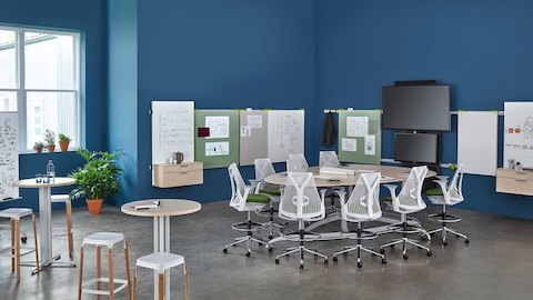 Cadeiras de escritório Sayl cercam uma mesa Exclave em um espaço aberto de colaboração. Selecione para ir para a página do produto Exclave.
