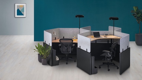 A group of Catena Office Landscape workstations in a honeycomb configuration with Ode Lamps and black Aeron Chairs.