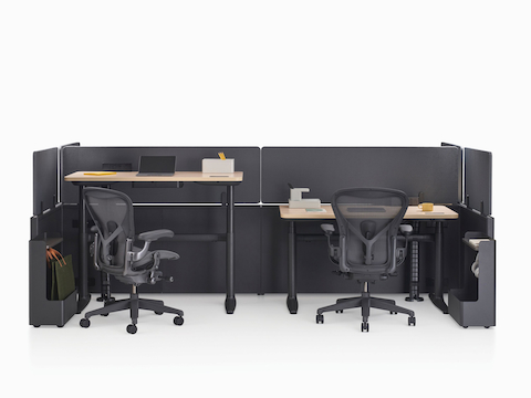 Catena Office Landscape workstations with light wood surfaces, black panels, and two black Aeron Chairs.