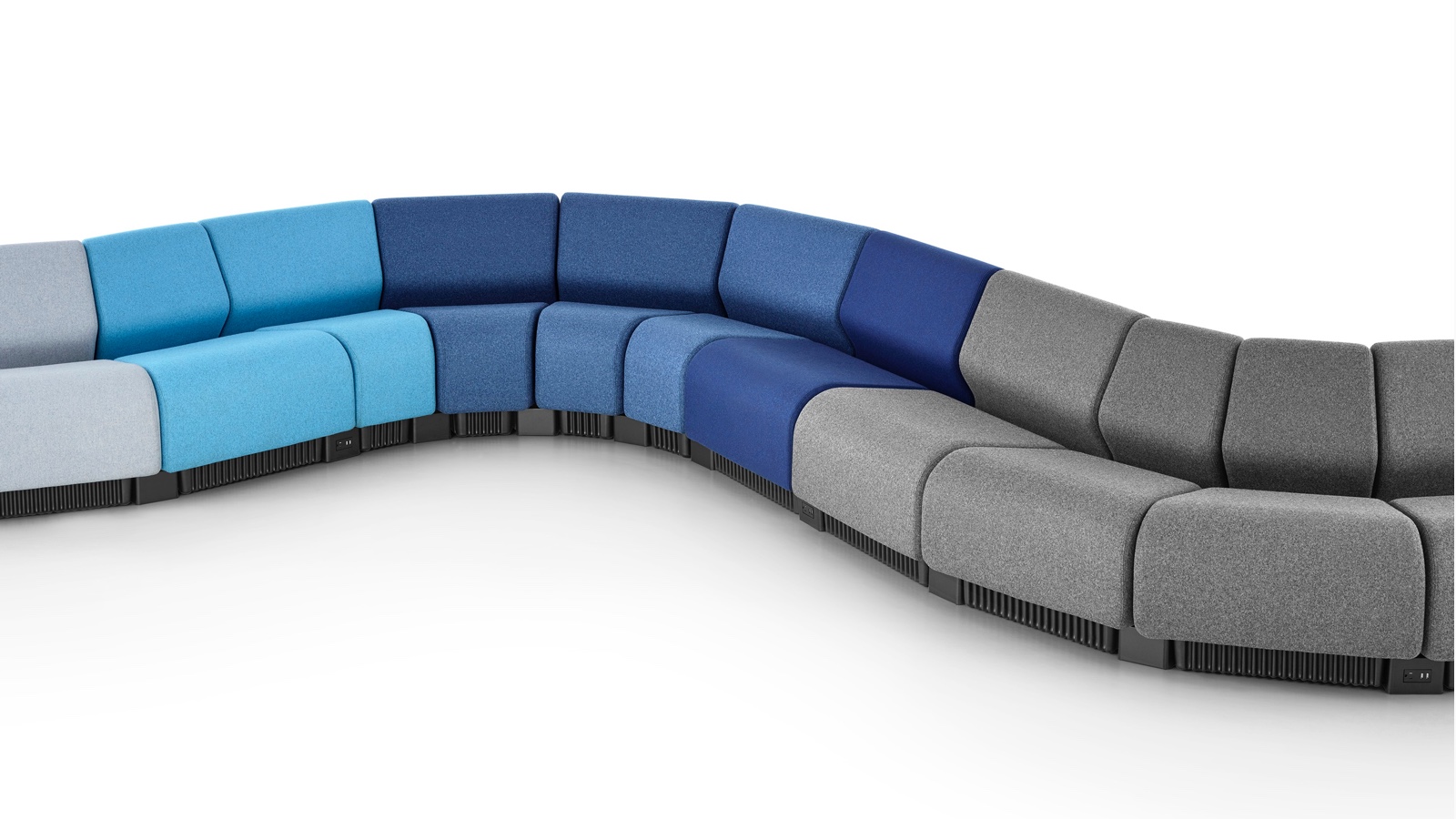 Configuração de assentos em serpentina formados com módulos de assentos modulares Chadwick em tons de cinza e azul.