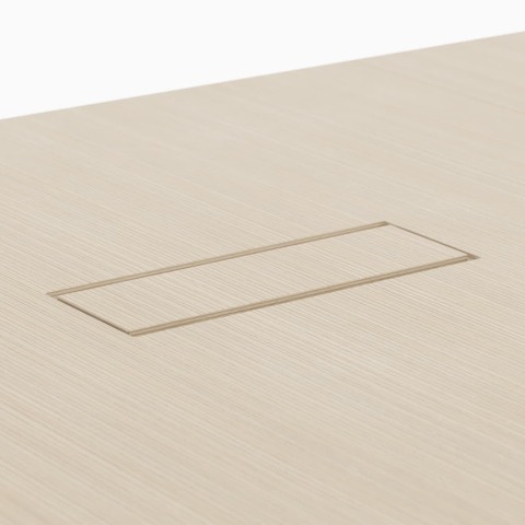 A detail view of the veneer power access cutout with available grain matching that easily brings power and data from the floor to the surface of the table.
