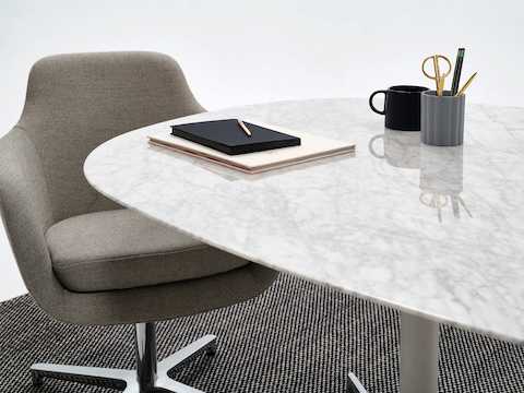Ein Civic Tisch aus weißem Marmor mit einem grauen Saiba Bürostuhl.