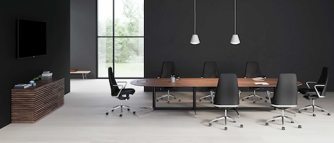 A large oval Civic Table with a walnut surface accompanied by 7 black leather Taper chairs. A large oval Civic Table with a walnut surface accompanied by 7 black leather Taper chairs.