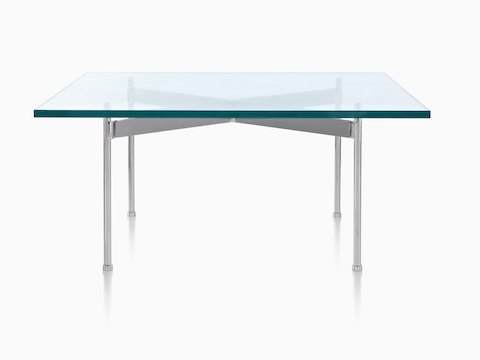 Een Claw-tafel met glazen blad, een rechthoekig oppervlak en vier metalen poten.
