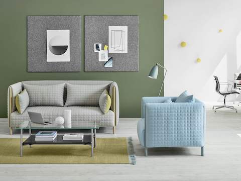 Un divanetto ColourForm grigio chiaro e una poltrona ColourForm azzurra in uno spazio di interazione casual.