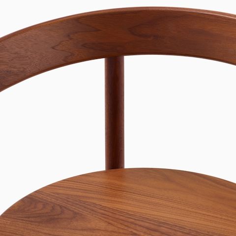 A close up detail shot of the wood seat and backrest of a Comma Chair with arms.