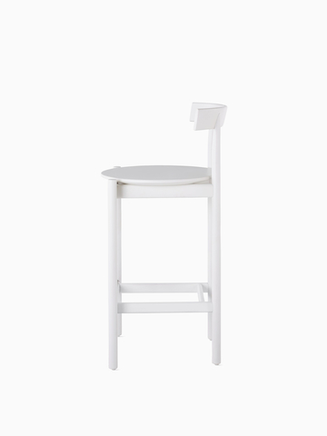Profile view of a white counter-height Comma Stool.