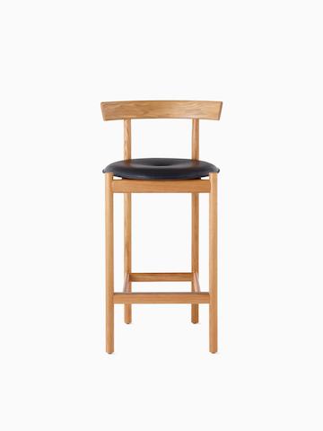 An oak Comma Stool with a seat pad, viewed from the front.