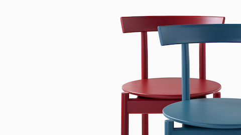 Detalle del primer plano de una silla Comma en azul frente a una silla Comma en rojo.