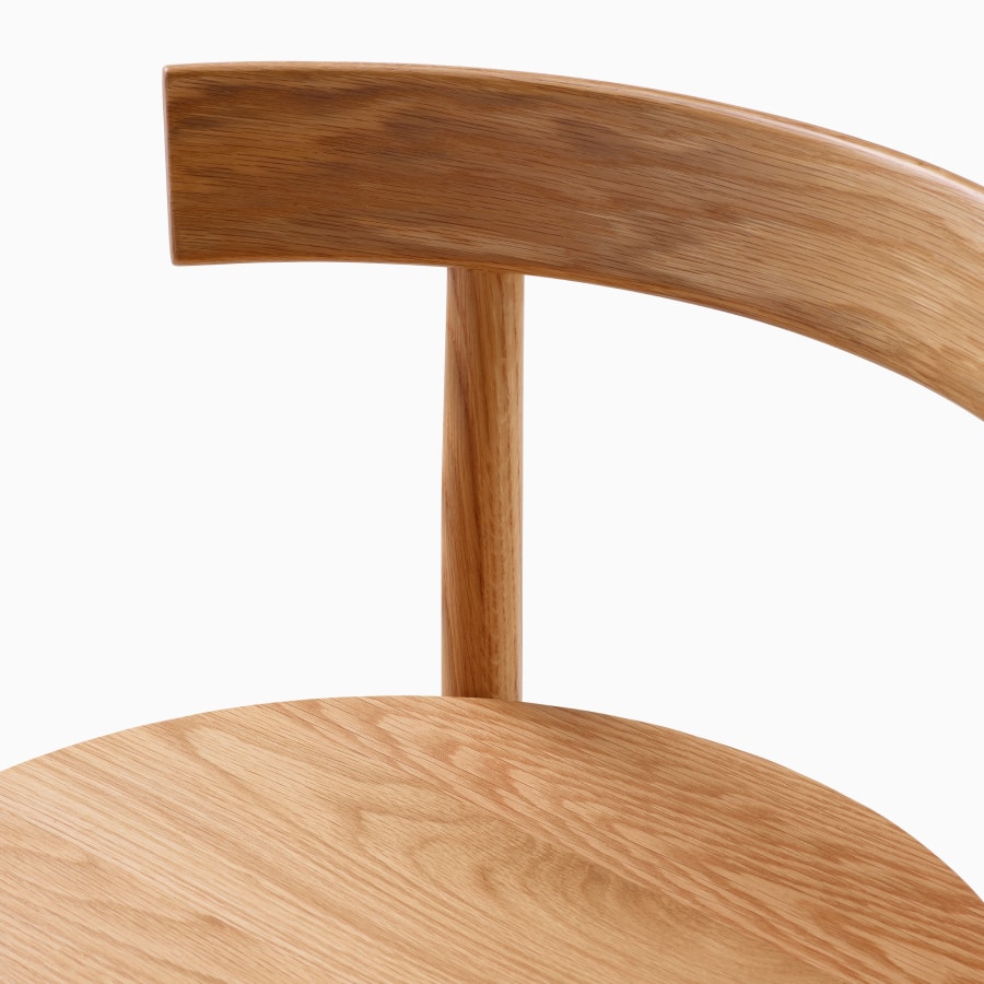 Dettaglio in primo piano del sedile e dello schienale in legno di uno sgabello Comma.